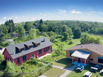 Image from overhead perspective of the UWM Saukville Field Station, two large buildings with a sprawling forested area behind them.